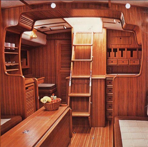 the inside of a wooden boat with shelves and drawers on each side, along with other items