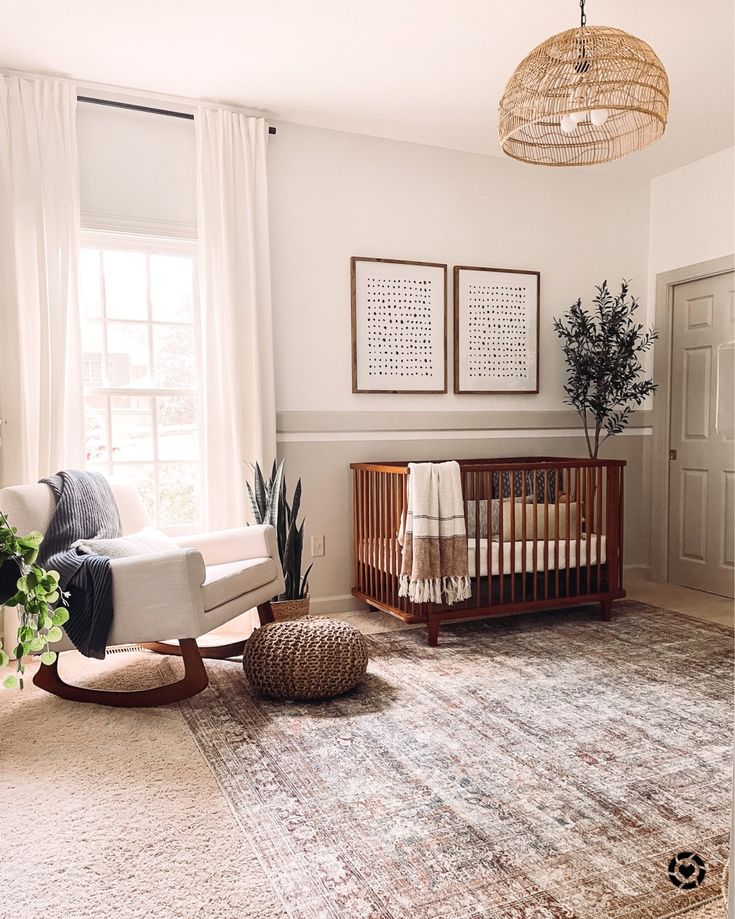 a woman sitting on the floor in front of a baby crib