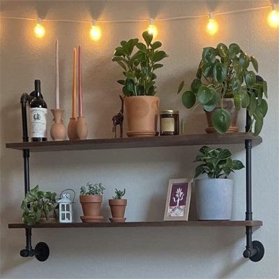 three shelves with plants and candles on them