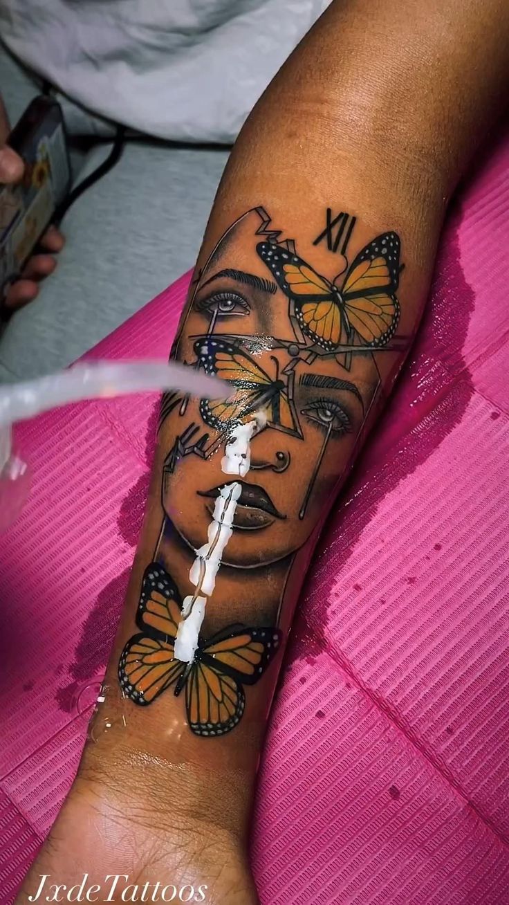 a woman's arm with butterflies on it and the face of a woman in butterfly wings