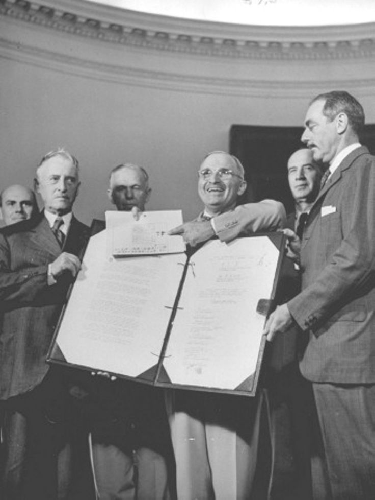 a group of men standing next to each other in front of a large sheet of paper