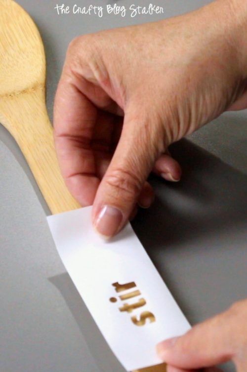 someone is cutting out the word sushi on a piece of paper with a wooden spoon