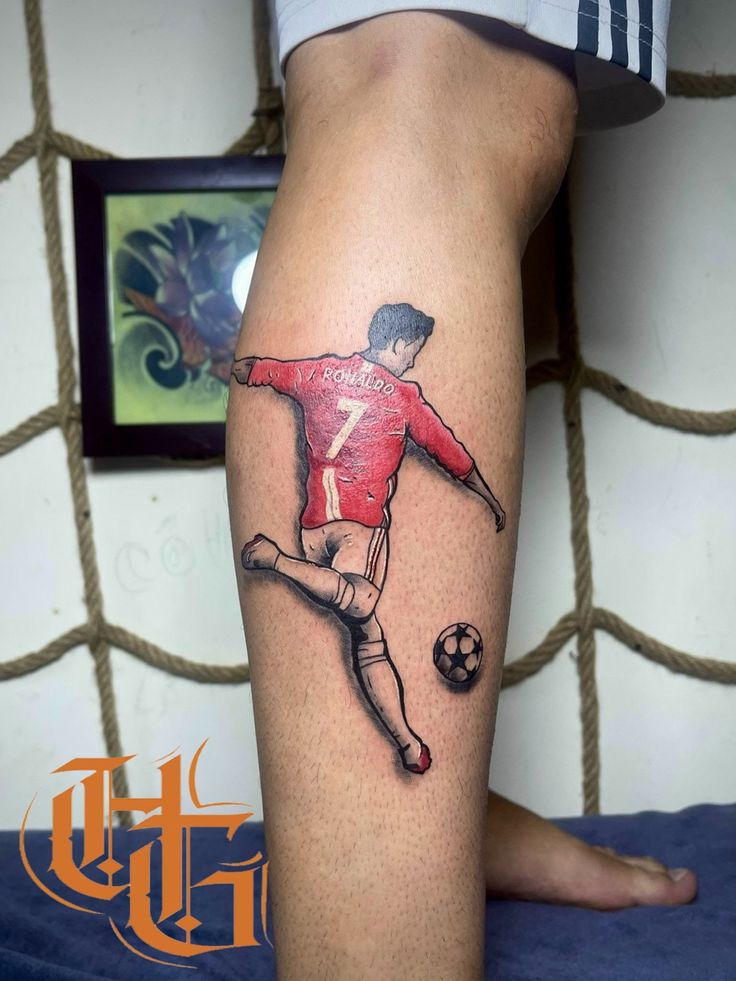 a man with a soccer tattoo on his leg