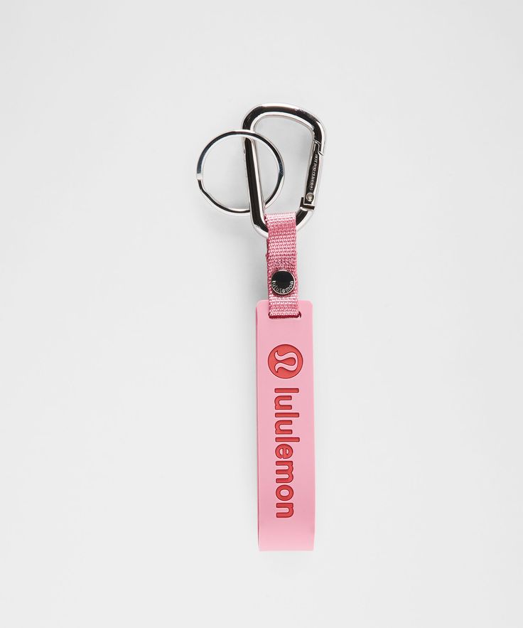 a pink keychain with the word london printed on it, hanging from a hook