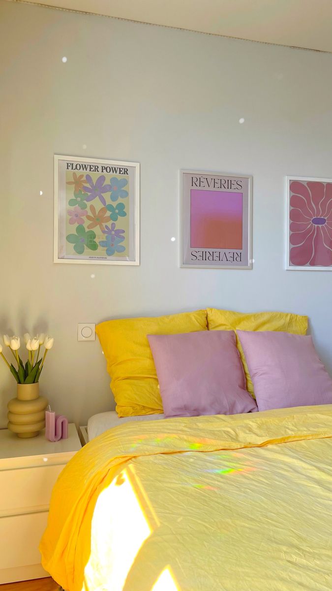 a bed with yellow sheets and pink pillows