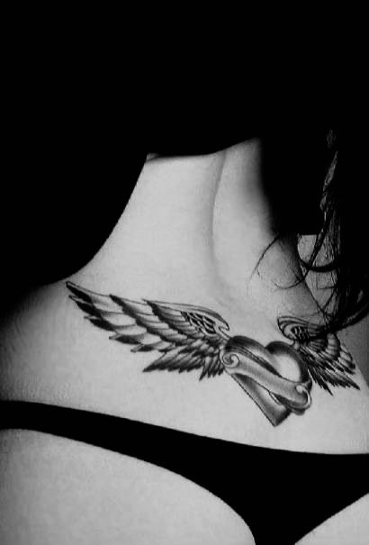 a woman's chest with wings and a heart tattoo on her left side ribcage