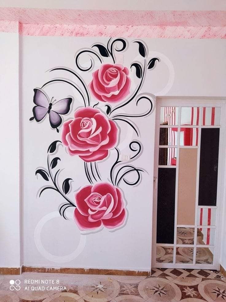 the wall is decorated with pink roses and black butterflies on white walls, along with an open door