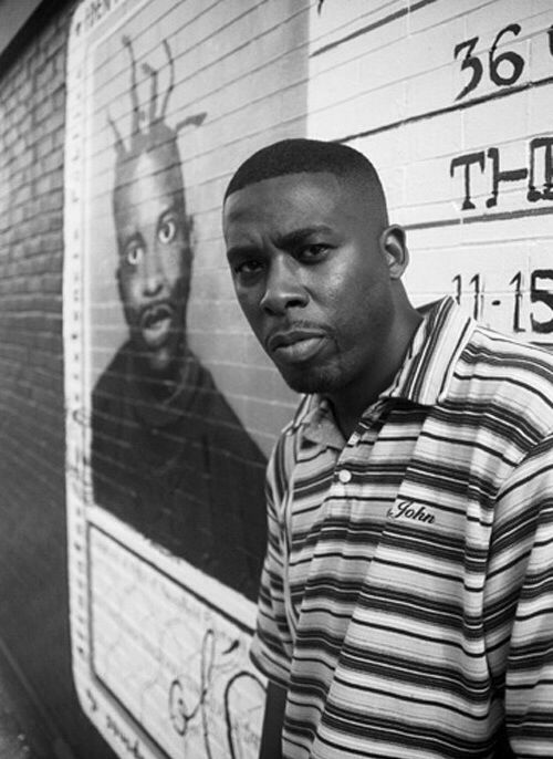 a man standing in front of a wall with posters on it