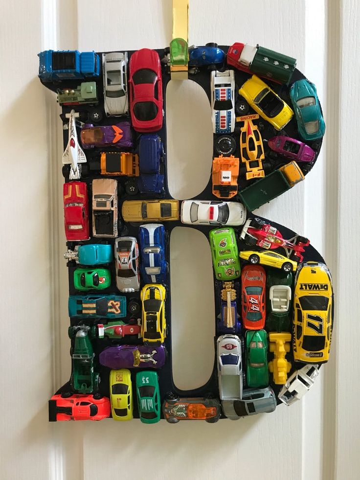 the letter b made out of toy cars is hanging on a door handle with magnets