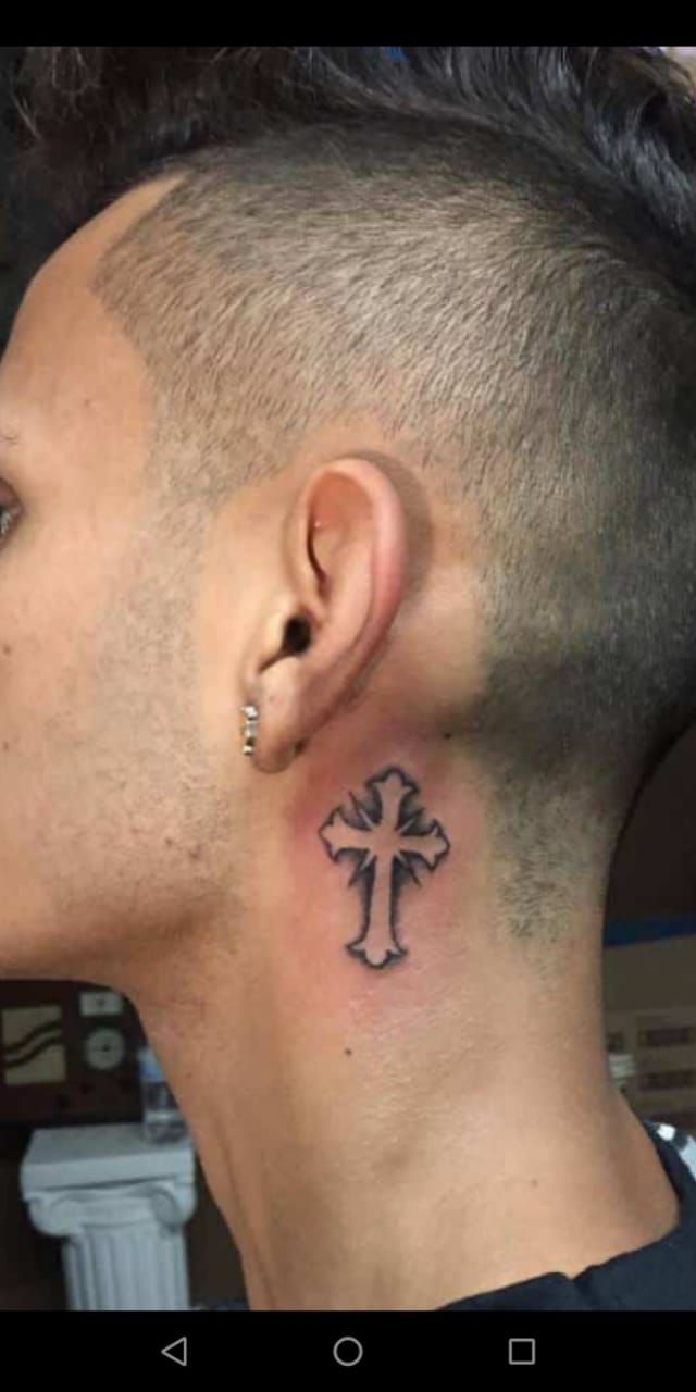 a man with a cross tattoo on his neck and behind the ear is a black outline