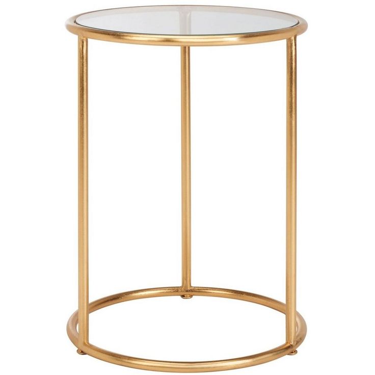 a gold metal and glass side table with a circular base on an isolated white background