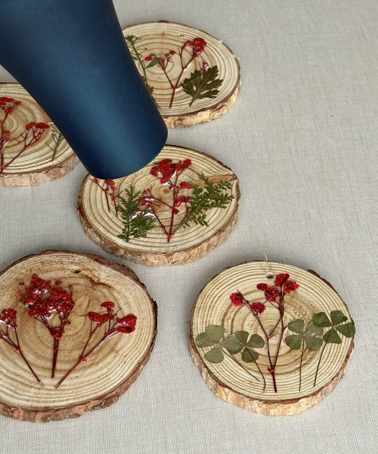 four pieces of wood with red flowers and leaves on them