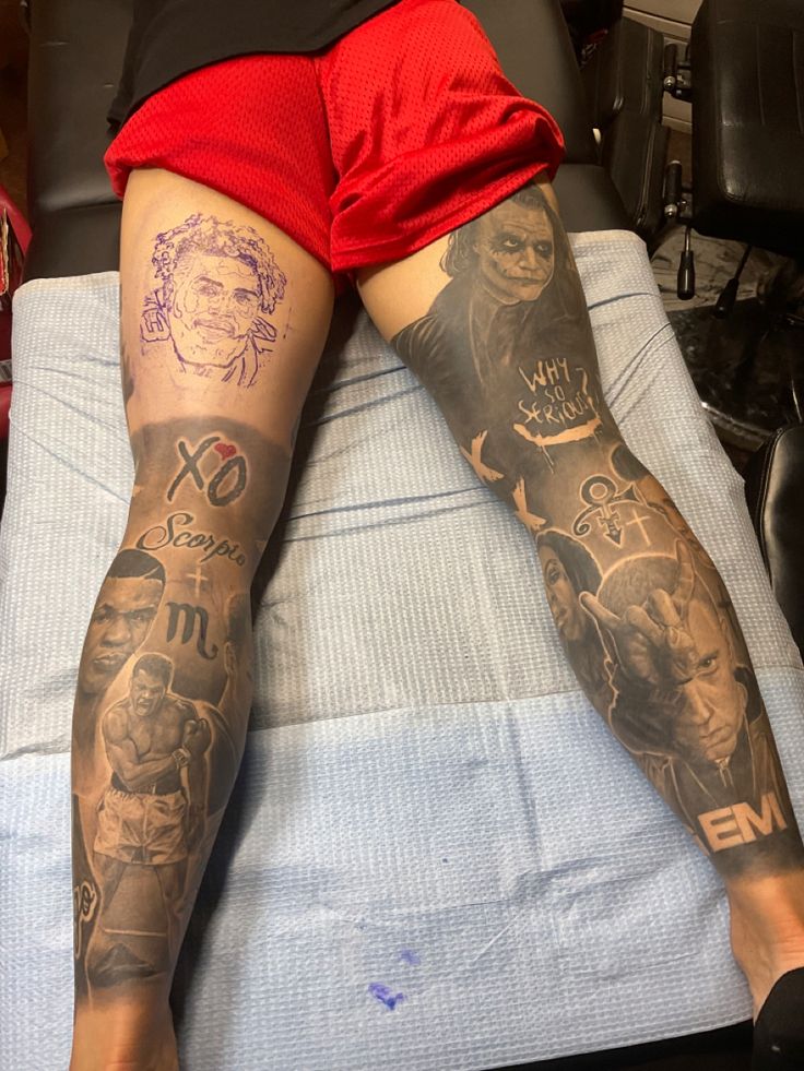 a person with tattoos on their legs laying down