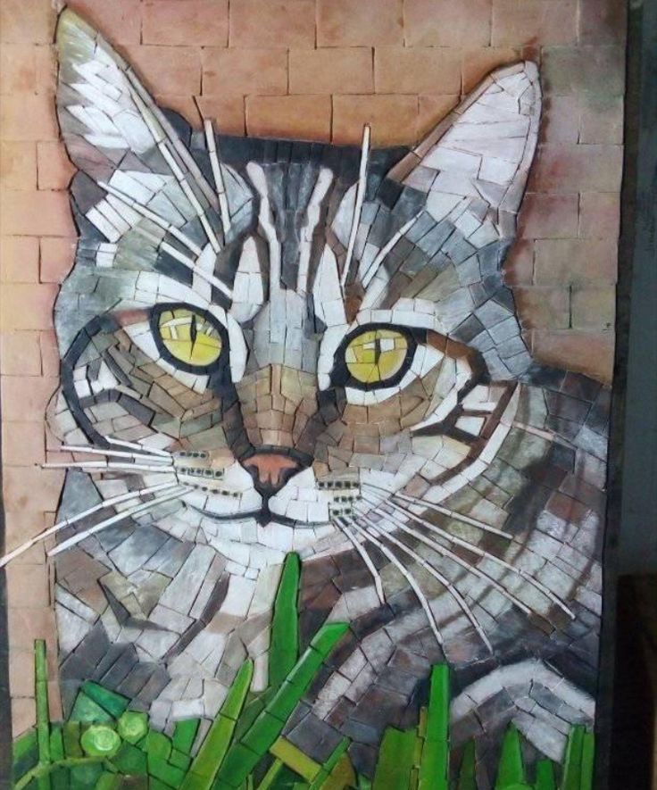 a painting of a cat with yellow eyes and green grass in front of a brick wall