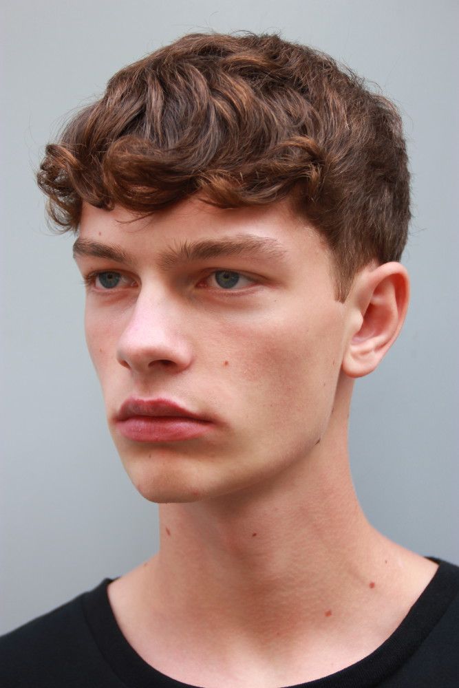 a close up of a person wearing a black t - shirt and looking at the camera