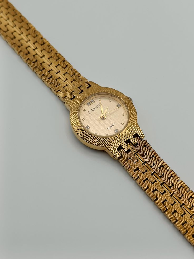 This stunning gold-tone watch combines elegance and luxury with its intricate, jeweled cuff design. Featuring a sleek gold dial and an eye-catching bracelet, it's both a statement piece and a timekeeper--perfect for adding a touch of glamour to any outfit. Comes with an extra link.  In working order.  Has minor wear on, please see pictures. Length: 19cm Dial width: 2.4cm Vintage Gold Stainless Steel Watch, Formal Metal Watch With Round Dial, Formal Metal Watches With Round Dial, Gold Stainless Steel Diamond Watch With Round Dial, Formal Metal Watches, Elegant Metal Analog Watch, Gold Stainless Steel Diamond Watch Analog, Gold Diamond Watch With Metal Round Dial, Elegant Gold Stainless Steel Watch Accessories