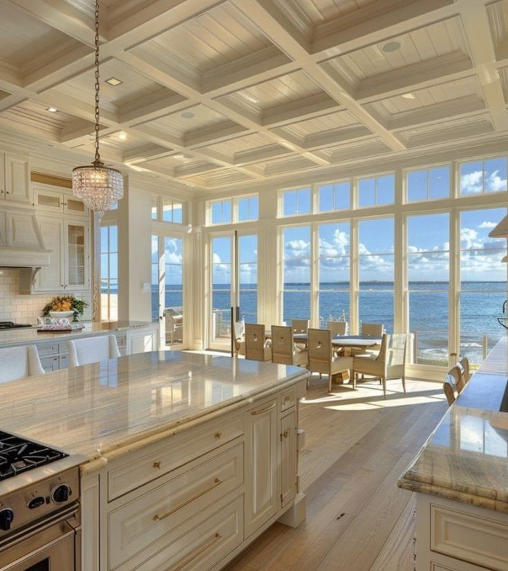 a large kitchen with an island counter top next to the ocean