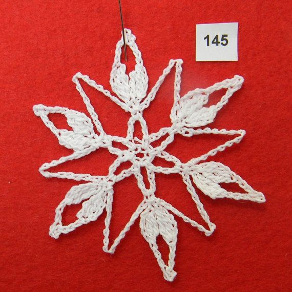 a white crocheted snowflake ornament on a red background