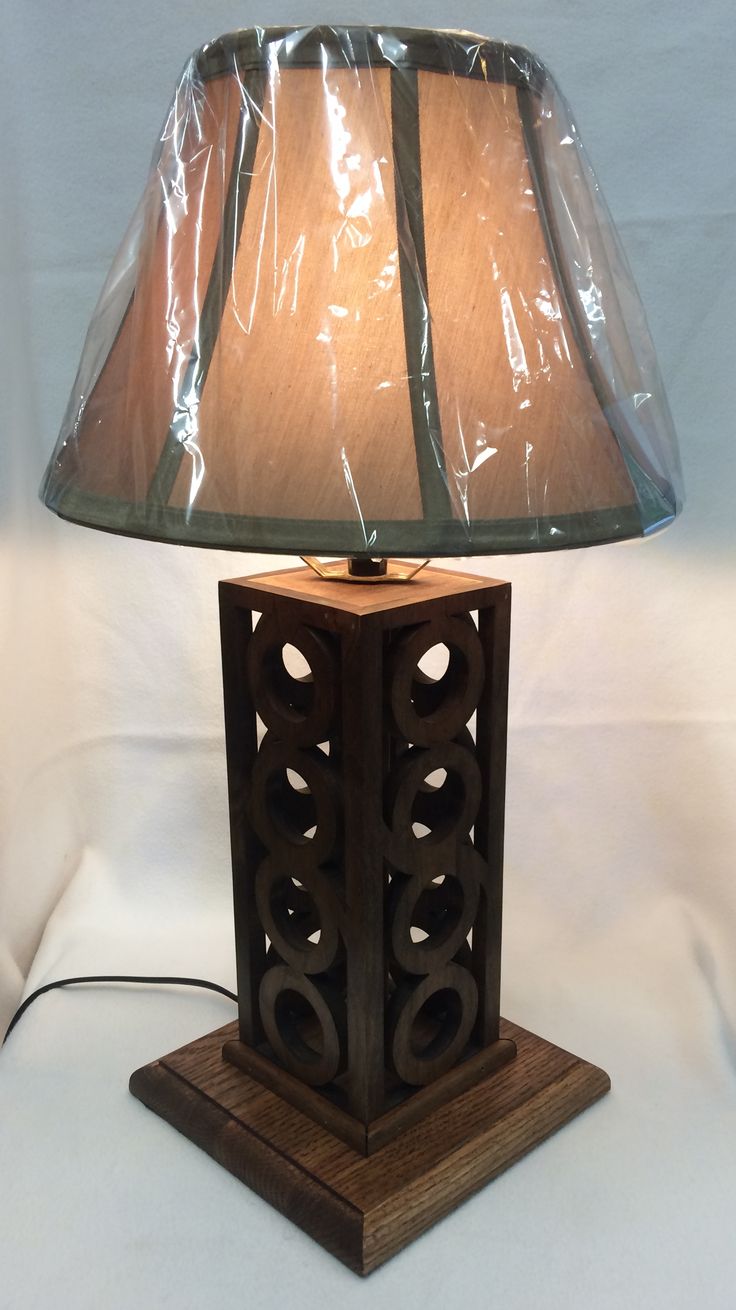 a lamp that is sitting on top of a wooden base with a plastic covering over it