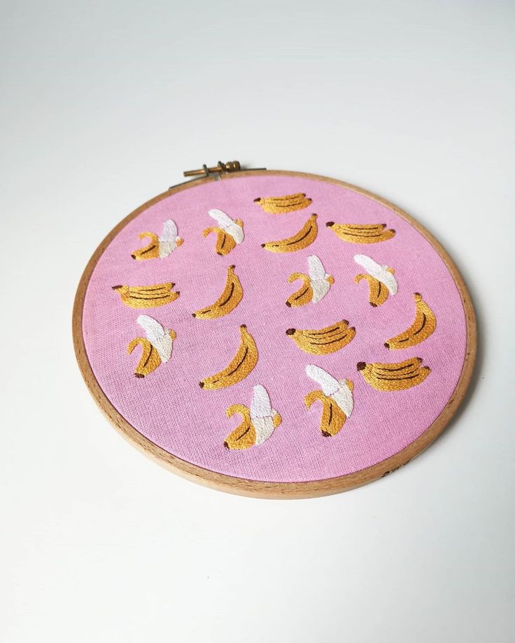 a pink and yellow embroidery with bananas on it