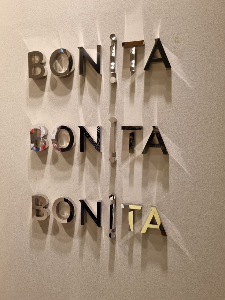 the words bonita, bonita, bonita written in cut out letters on a white wall