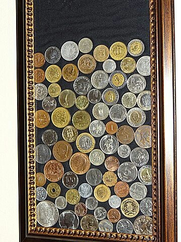 a wooden frame with many different coins on it