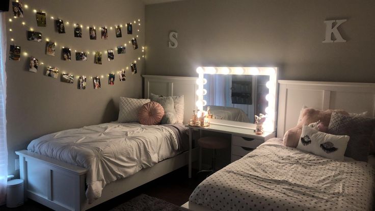 two twin beds in a small room with lights on the wall