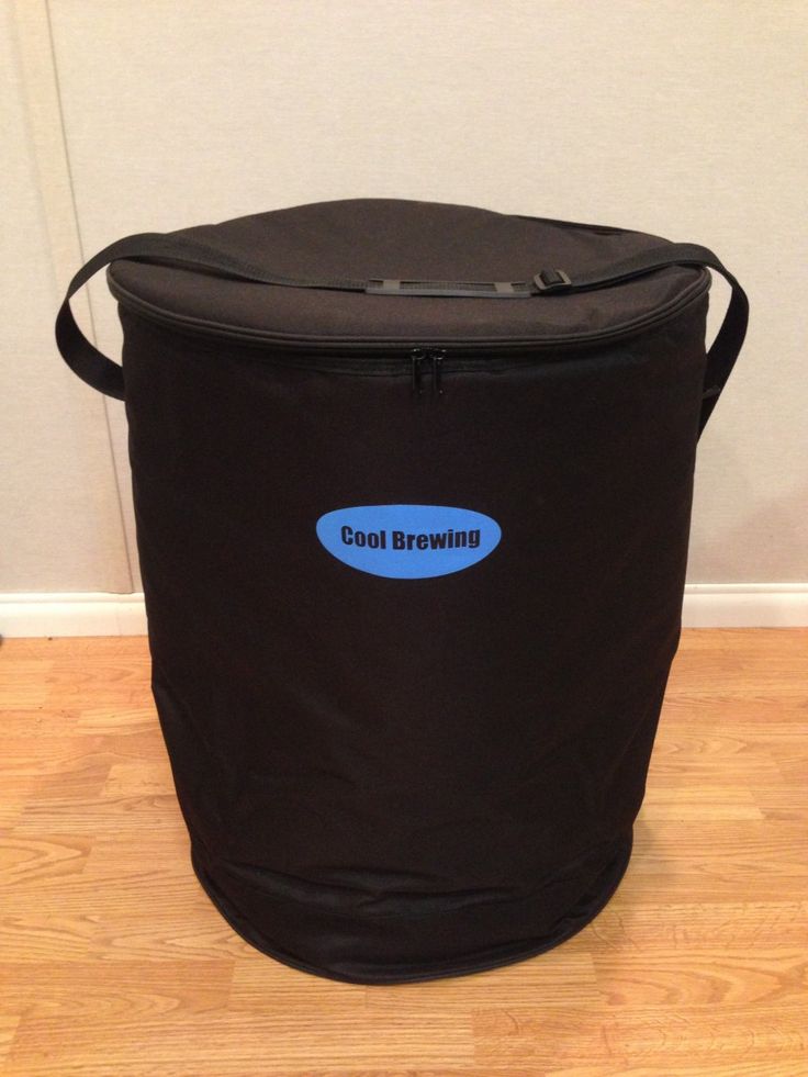 a large black bag sitting on top of a hard wood floor next to a wall