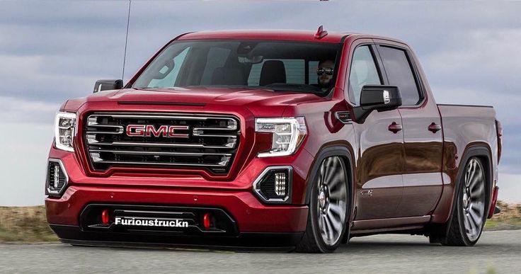 a red gmc truck driving down the road