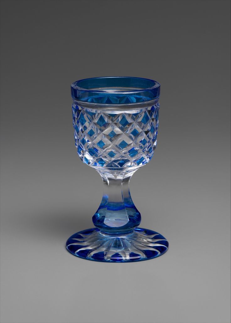 a blue glass cup sitting on top of a table