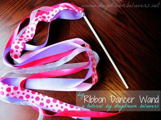 ribbon dancer wands on a wooden table with pink and white polka doted ribbons