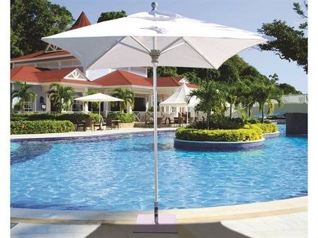 an outdoor swimming pool with white umbrellas