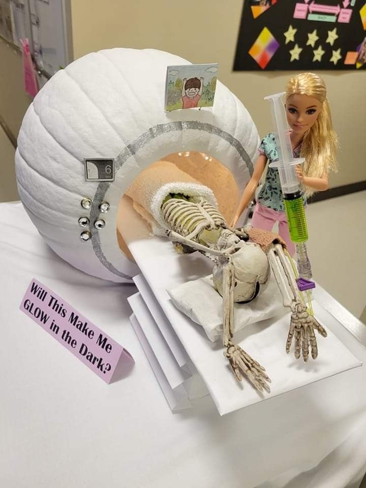 there is a doll and skeleton on the table with other items in front of it