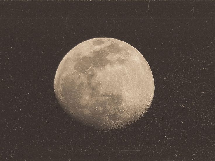 an old photo of the moon taken in black and white, with stars around it