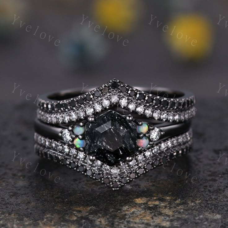 a black and white diamond ring set on top of a stone