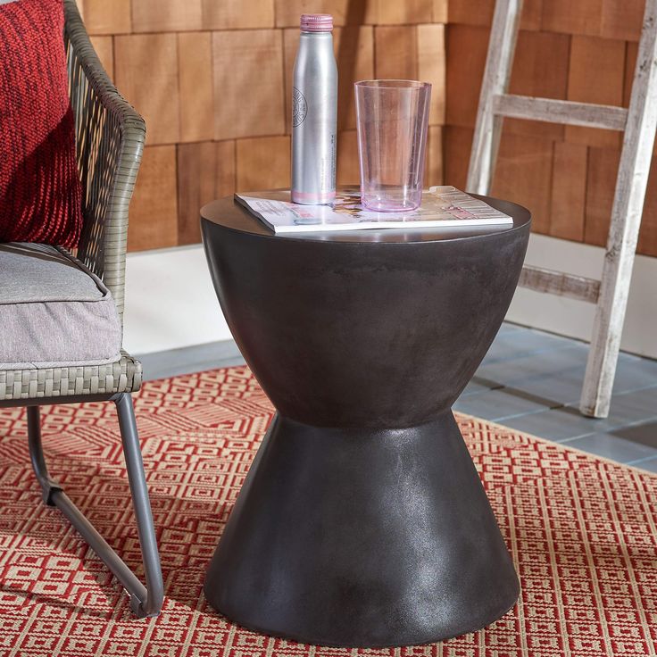 a table with two glasses on top of it next to a chair and ladder in the background