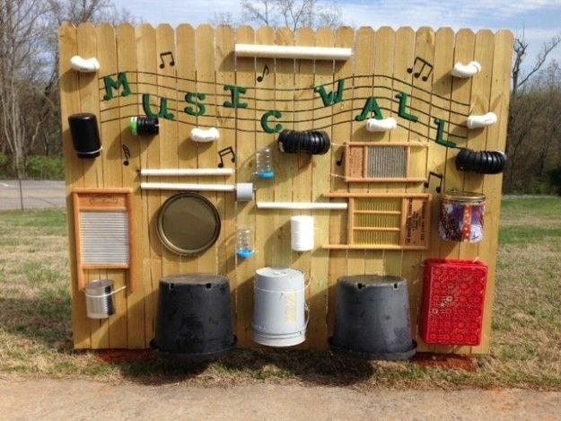 a wooden music box with musical notes on the wall and buckets next to it