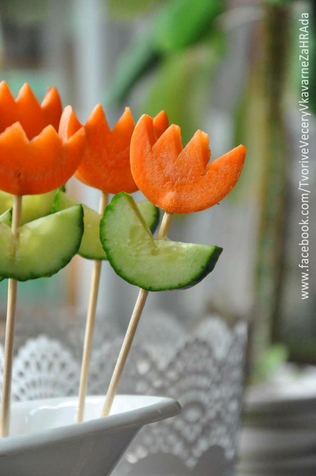 carrots and cucumbers are arranged on skewers in a white bowl