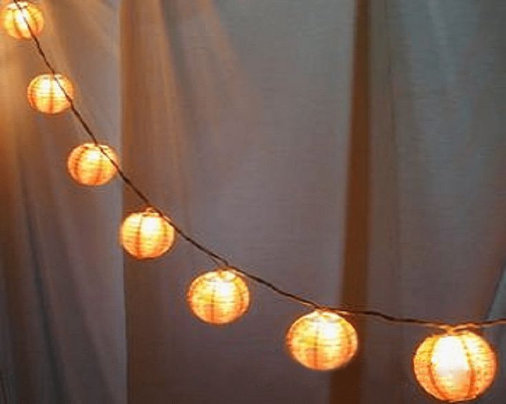 a string of paper lanterns hanging from a curtain