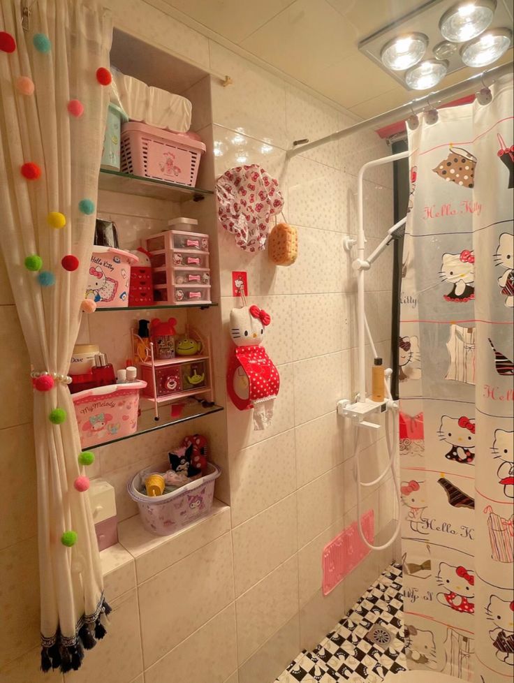 a bathroom decorated in pink and white with hello kitty decorations on the shower curtain rod