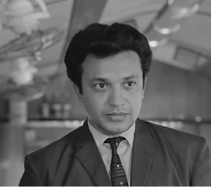 a black and white photo of a man in a suit looking at the camera with an intense look on his face