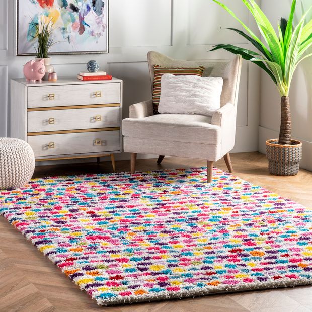 a living room area with a chair, rug and potted plant on the floor