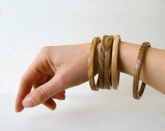 a woman's arm with three different bracelets on it, one is holding the other