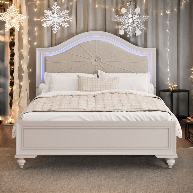 a white bed with snowflakes hanging from the ceiling and lights on the wall