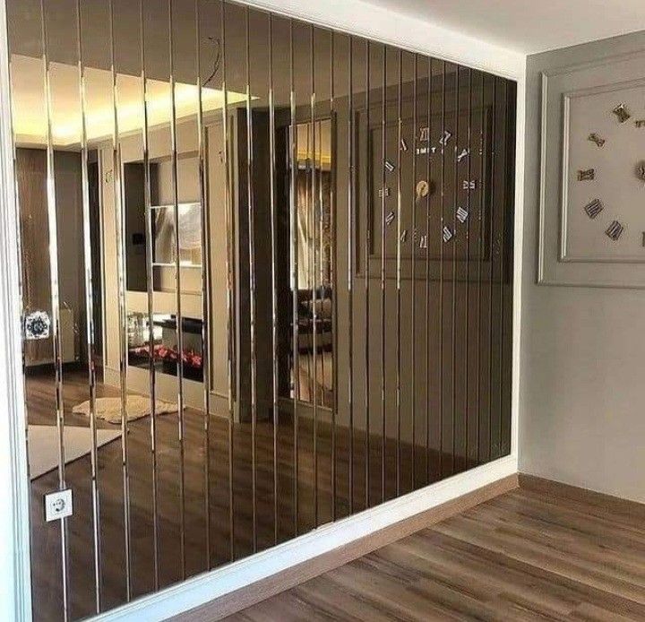 an empty room with mirrored walls and wood flooring in front of the mirror wall