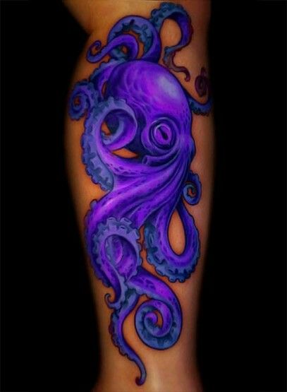 an octopus tattoo on the side of a woman's leg, with purple ink