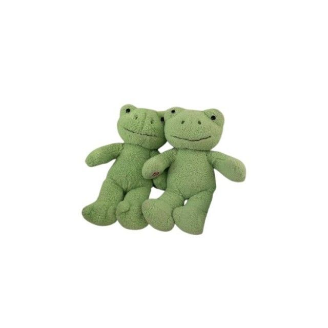 two green frog stuffed animals sitting next to each other on a white background with space for text