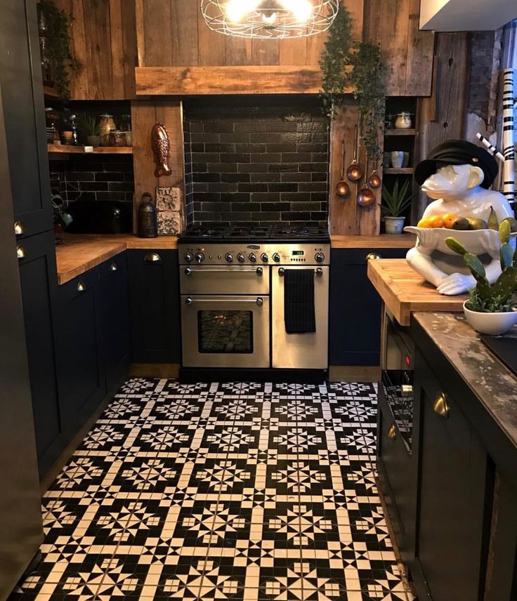 a kitchen with black and white tile flooring next to a stove top oven, counter tops and cabinets