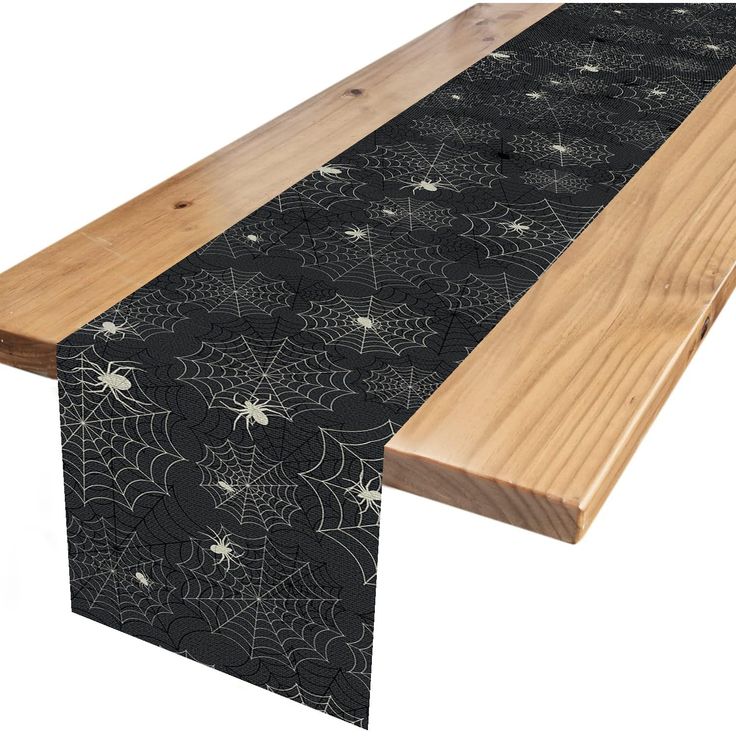 a wooden table with spider webs on it and black fabric over the top, along with wood planks