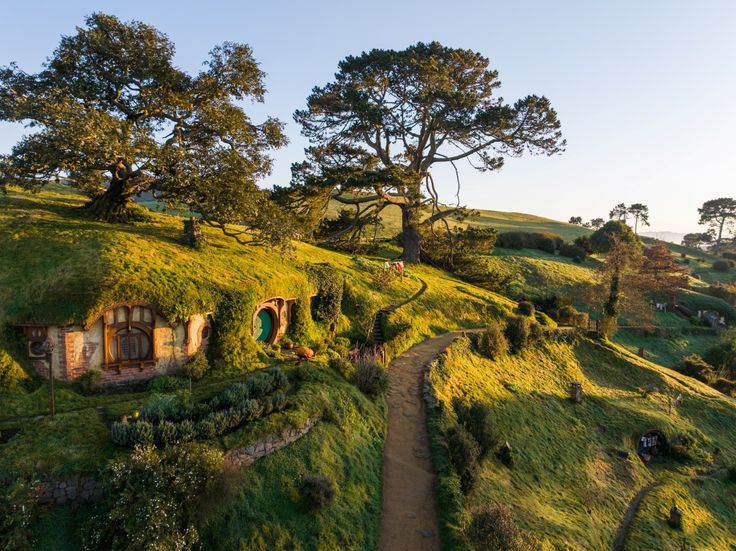 an aerial view of a hobbot house in the middle of a green field